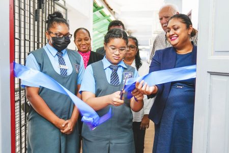 Minister Priya Manickchand (right) and a student cutting the ribbon for the smart room while the Headmistress and Chairman of the Board of Governors look on 