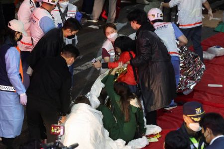 People receive medical help from rescue team members at the scene where dozens of people were injured in a stampede during a Halloween festival in Seoul, South Korea, October 29, 2022. REUTERS/Kim Hong-ji
