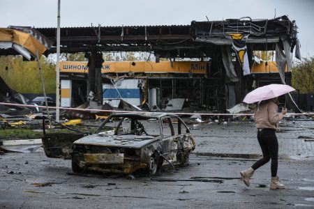 A woman passes by a gas station destroyed by yesterday's Russian military strike, as Russia's attack on Ukraine continues, in Dnipro October 26, 2022.  REUTERS/Mykola Synelnykov