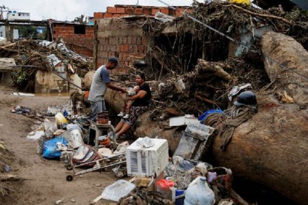 People sit surrounded by belongings following floods due to heavy rains, in Las Tejerias, Aragua state, Venezuela October 9, 2022. REUTERS/Leonardo Fernandez Viloria 