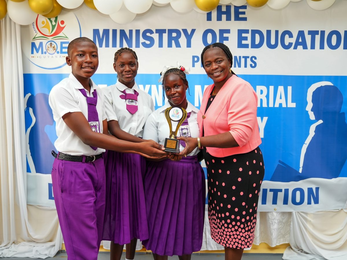 The winning team representing the Winifred Gaskin Memorial Secondary School receiving their trophy from the Assistant Chief Education Officer (Secondary),  Tiffany Harvey. (Ministry of Education photo)