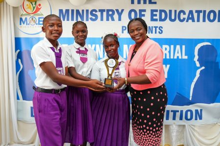 The winning team representing the Winifred Gaskin Memorial Secondary School receiving their trophy from the Assistant Chief Education Officer (Secondary),  Tiffany Harvey. (Ministry of Education photo)