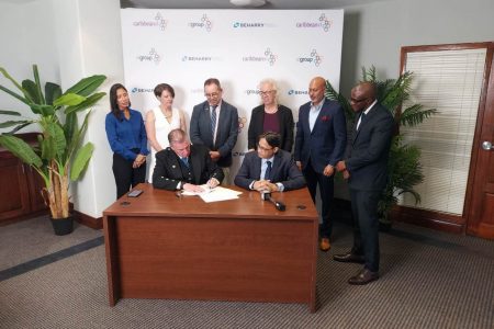 Chief Executive Officer (CEO) of XL Group, Colin Laird (seated at left) and Chairman of the Beharry Group, Anand Beharry (seated at right) signed the agreement for the joint venture. British High Commissioner Jane Miller and Canadian High Commissioner Mark Berman also witnessed the signing.