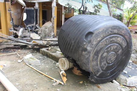 The aftermath of the explosion. Pieces of concrete can be seen on the ground as well as a black water tank, a part of which was melted due to the explosion.   