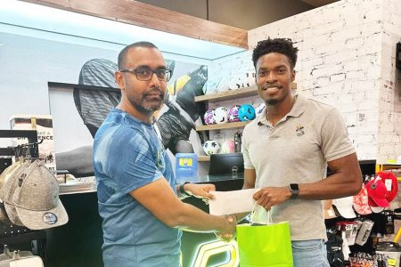 The Chief Executive Officer (CEO) of MVP Sports, Ian Ramdeo (left) hands over the endorsement package to Arinze Chance at the store’s Giftland Mall location.