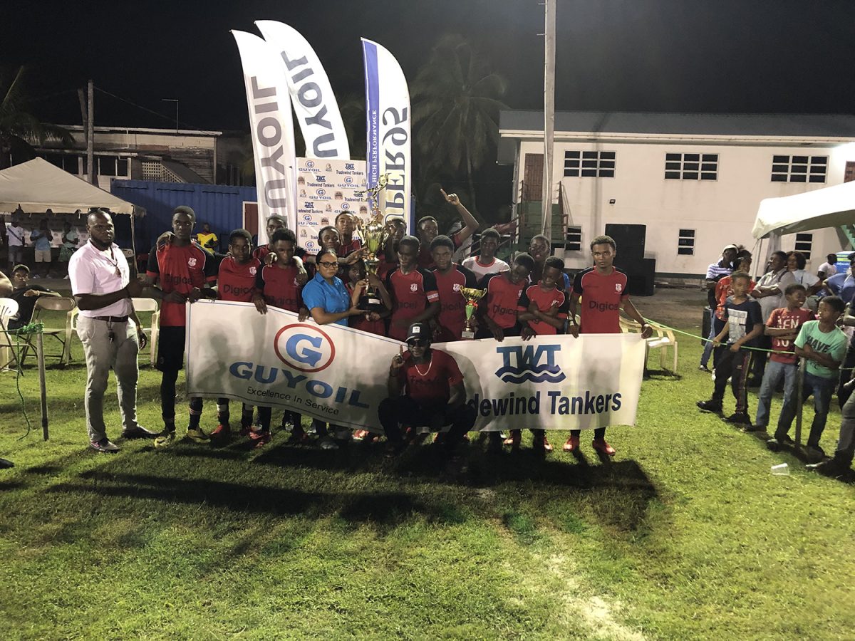 Christianburg/Wismar Secondary captain Kelvin Hintzen receives the championship trophy from Vanessa Madramuthoo, Marketing and Sales Manager (Ag) of GuyOil in the presence of teammates after they won the third GuyOil/Tradewind Tankers U18 Secondary Schools Football League championships.