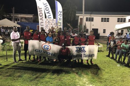 Christianburg/Wismar Secondary captain Kelvin Hintzen receives the championship trophy from Vanessa Madramuthoo, Marketing and Sales Manager (Ag) of GuyOil in the presence of teammates after they won the third GuyOil/Tradewind Tankers U18 Secondary Schools Football League championships.