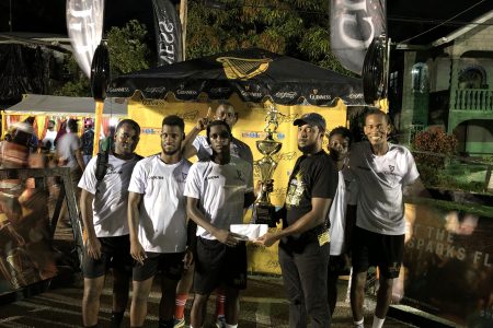 Stephon Reynolds of Liliendaal Hustlers receives  the championship trophy (in the presence of teammates) from Guinness Brand Manager Jeoff Clement 