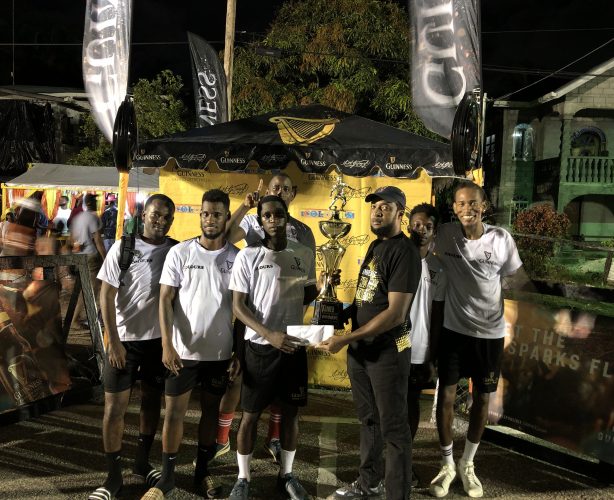 Stephon Reynolds of Liliendaal Hustlers receives  the championship trophy (in the presence of teammates) from Guinness Brand Manager Jeoff Clement 