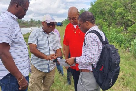 Minister of Public Works Juan Edghill (second from right) being briefed by his technical team on the changes along the coast.  (Ministry of Public Works photo)