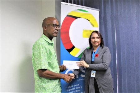 Minister of Labour Joseph Hamilton (left) receives a cheque from GYSBI Human Resource Manager, Lilowtie Chintamani (GYSBI photo)