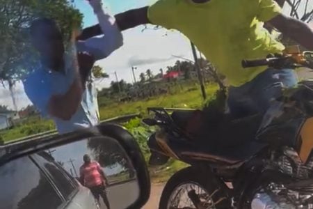 A screenshot from a video showing the policeman (left) being assaulted