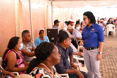 Minister in the Ministry of Housing and Water, Susan Rodrigues (right) interacting with some of the informal settlers yesterday. (CHPA photo)