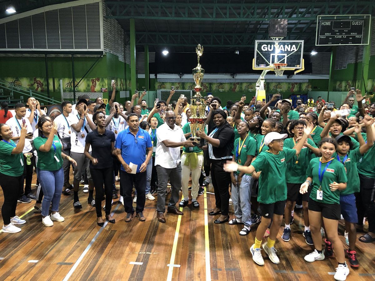 Director of Sport Steve Ninvalle presents the championship trophy to Suriname Minister of Sport and Regional Development Gracia Emmanuel in the presence of a celebrating Dutch contingent.
