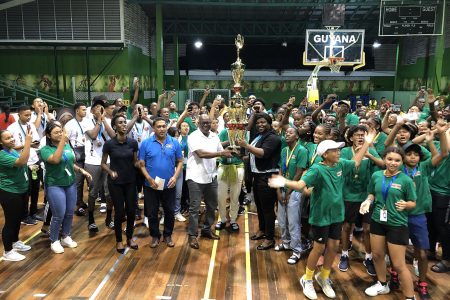 Director of Sport Steve Ninvalle presents the championship trophy to Suriname Minister of Sport and Regional Development Gracia Emmanuel in the presence of a celebrating Dutch contingent.
