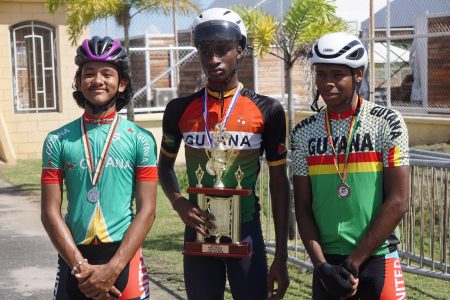 Winners Row! Guyana’s Sherwin Sampson (Centre) Alex Leung (left) and Aaron Newton pose for a photo with Team Guyana’s first place trophy for the discipline of cycling. (Emmerson Campbell photo)