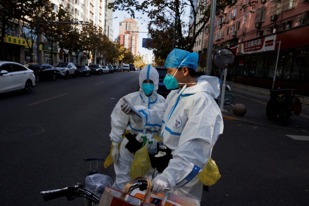 Pandemic prevention workers in protective suits stand on a street as outbreaks of coronavirus disease (COVID-19) continue in Beijing, November 21, 2022. REUTERS/Thomas Peter