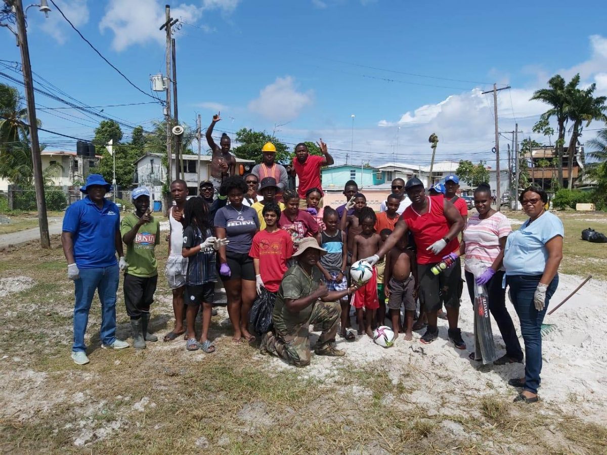 Director of Sport Steve Ninvalle, left, with the youth and other residents of West Ruimveldt during yesterday’s cleanup exercise.