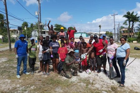 Director of Sport Steve Ninvalle, left, with the youth and other residents of West Ruimveldt during yesterday’s cleanup exercise.