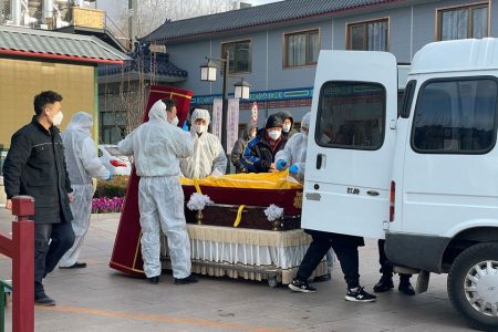 Workers in protective suits transfer a body in a casket at a funeral home, amid the coronavirus disease (Covid-19) outbreak in Beijing, China December 17, 2022.