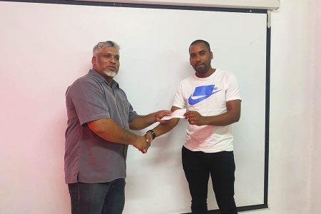 Small Business Bureau Chief Executive Mohamed Ibrahim (at left) hands over a cheque to one of the recipients 