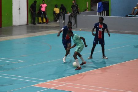 Dorwin George (green) of Stabroek Ballers trying to evade the impending challenge of Jaleel Hamilton of Future Stars during their semi-final fixture in the MVP Sports Futsal Championship.