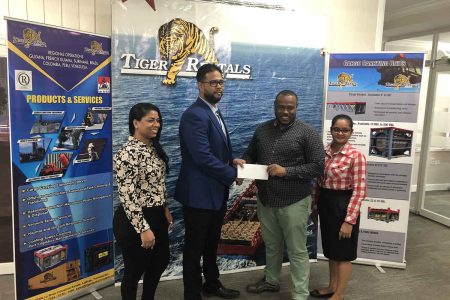 Petra Organization Co-Director Troy Mendonca (2nd from right) receiving
the sponsorship cheque from Shane Singh, Manager of Tiger Rentals
Guyana in the presence of company representatives
