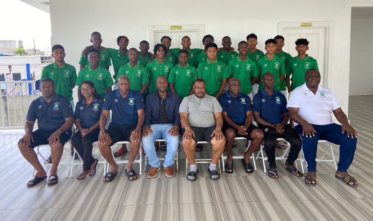 Tournament coordinator Troy Mendonca (sitting 4th from right) and GFF President Wayne Forde (5th from right) posing with members of the SVB Academy of Suriname at the National Training Centre