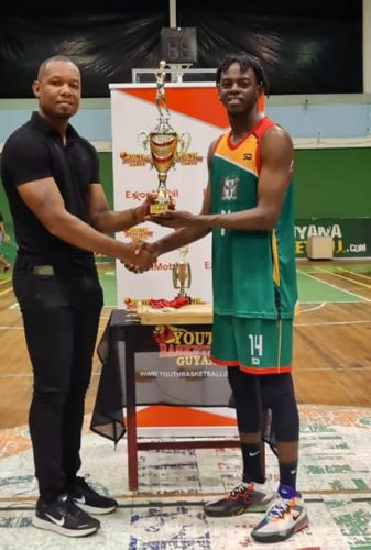 NSC member Dellon Davidson presenting the Tertiary championship trophy to Shaquawn Gill, the captain
of the University of Guyana
