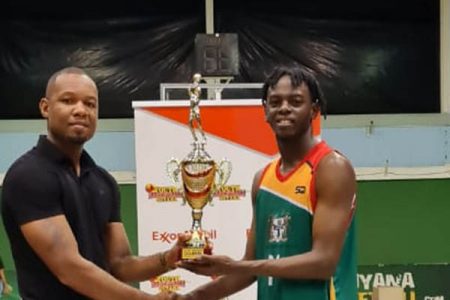 NSC member Dellon Davidson presenting the Tertiary championship trophy to Shaquawn Gill, the captain
of the University of Guyana
