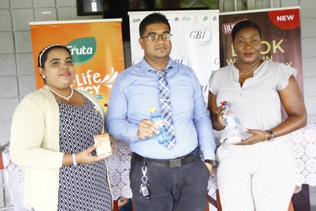 GBI Finance Manager Khemray Misir (centre) displaying the Busta brand while Petra Organization representatives Nareeza Latif (left) and Jacklyn Boodie showcase the
Fruta and Oasis Water brands respectively that will feature in the KFC Goodwill Series  