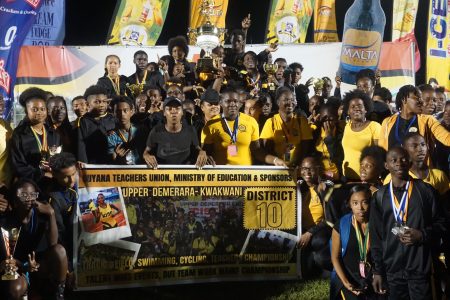 The victorious athletes of District 10 with the coveted Champion of Champions trophy during the closing ceremony of the 60th edition of the National Schools Swimming, Cycling and Track and Field Championships on Friday. (Emmerson Campbell photo)