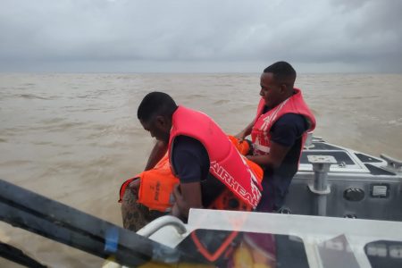 Coast Guard members rescuing one of the men. (GDF photo)