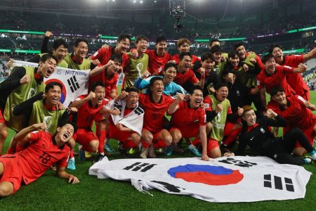 South Korea players pose with a flag after the match as South Korea qualify for the knockout stages REUTERS/Wolfgang Rattay
