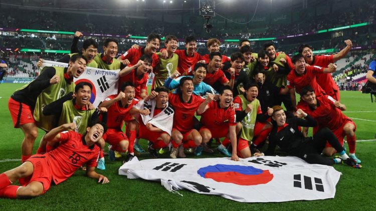 South Korea players pose with a flag after the match as South Korea qualify for the knockout stages REUTERS/Wolfgang Rattay