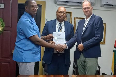 Minister of Public Works Juan Edghill (centre), with MARAD Director General, Captain Stephen Thomas (left) and a representative of Koole B.V, displaying the signed contract