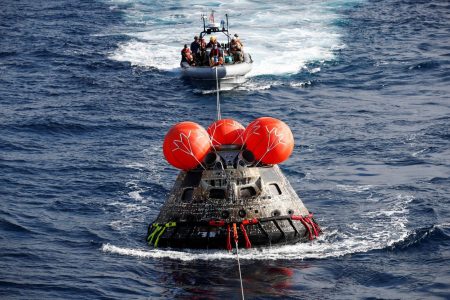 U.S. Navy divers attach winch cables to NASA’s Orion capsule after being successfully secured by a NASA and U.S. Navy team, off the coast of Baja California, Mexico, 11 December 2022. CAROLINE BREHMAN/Pool via REUTERS
