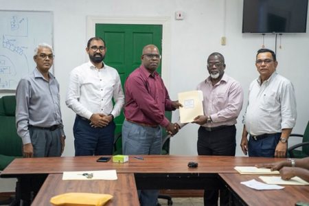 NAACIE General President Whitney Graham (third from left) handing over the signed agreement to GPL’s Acting Chief Executive Officer Renford Homer (DPI photo)