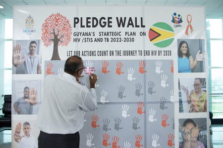 Health Minister Dr Frank Anthony signing the pledge wall. (Ministry of Health photo)