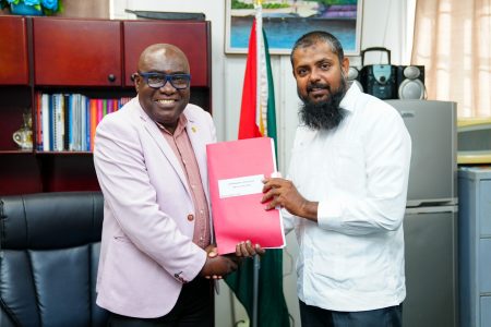 Saddam Hussain (right) in a handover with Dr Marcel Hutson (Ministry of Education photo)