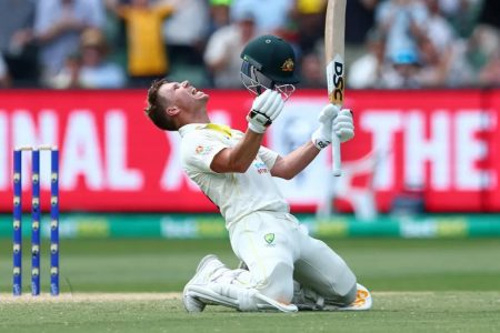 Australia opening batsman David Warner sinks to his knees after scoring a majestic double century in his 100th test.