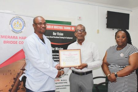 From left, General Manager of DHBC, Wayne Watson collecting the Masters of Apprenticeship certificate from Minister of Labour Joseph Hamilton and BIT’s Acting Chief Executive Officer/Secretary Saskia Eastman-Onwuzirike