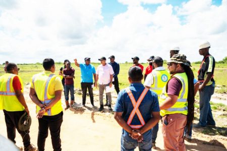 Housing and Water Minister, Collin Croal surrounded by a team of engineers and contractors as he inspected the ongoing works at the LBI Housing Scheme yesterday. (DPI photo)