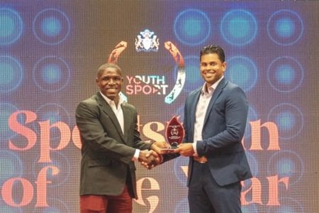 Desmond Amsterdam received his Senior Sportsman-of-the-Year of the year award from Minister of Culture, Youth and Sport, Charles Ramson Jr. on Sunday at the National Cultural Centre.