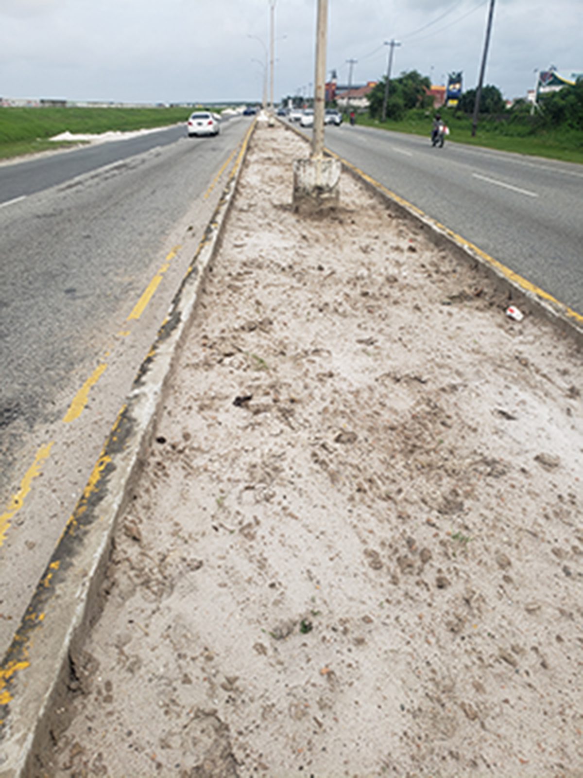Sand has replaced the earth on this median on the East Coast Highway in preparation for tiling.
