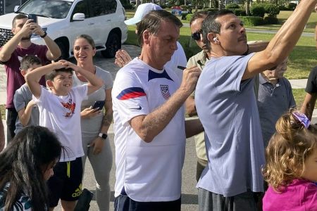Former Brazilian President Jair Bolsonaro, center, meets with supporters outside a vacation home where he is staying near Orlando, Fla., on Wednesday, Jan. 4, 2023.(Skyler Swisher | Skyler Swisher/Orlando Sentinel via AP)