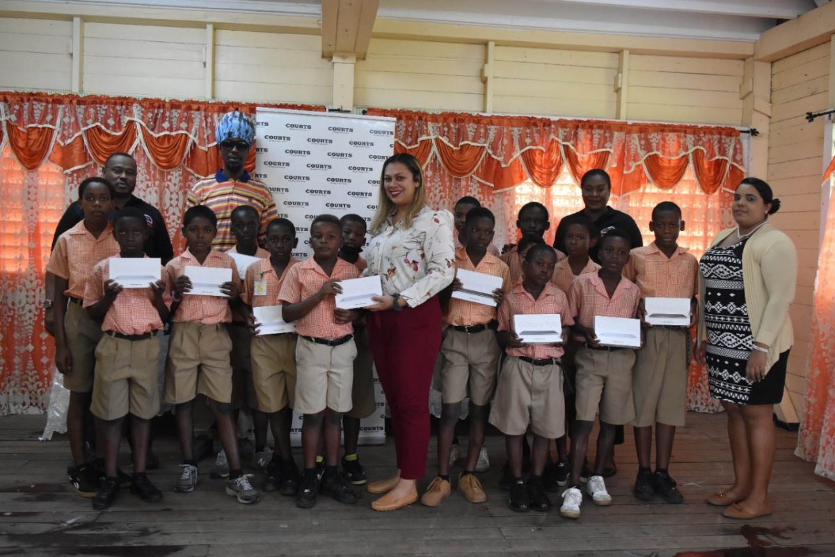 Marketing Manager Christel Van Sluytman presents the 16 Samsung tablets to the captain of Enterprise Primary in the presence of teammates and officials from the Petra Organization.