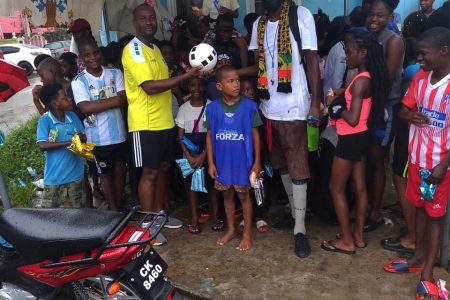 GFF President Wayne Forde (left) presenting the equipment of Coach Clifford Anthony of the Albouystown community on Monday.