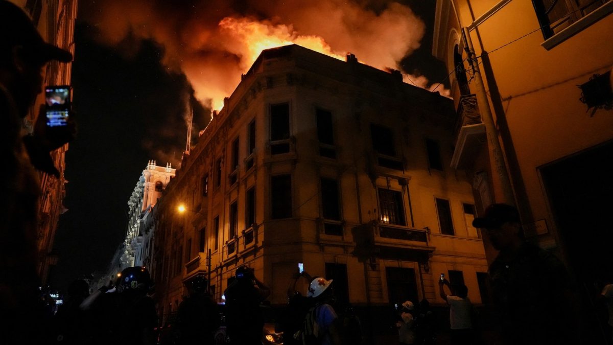 Smoke and flames rise on top of a building during the ‘Take over Lima’ march to demonstrate against Peru’s President Dina Boluarte, following the ousting and arrest of former President Pedro Castillo, in Lima, Peru January 19, 2023. (REUTERS/Angela Ponce)(REUTERS)