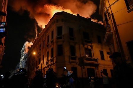 Smoke and flames rise on top of a building during the ‘Take over Lima’ march to demonstrate against Peru’s President Dina Boluarte, following the ousting and arrest of former President Pedro Castillo, in Lima, Peru January 19, 2023. (REUTERS/Angela Ponce)(REUTERS)